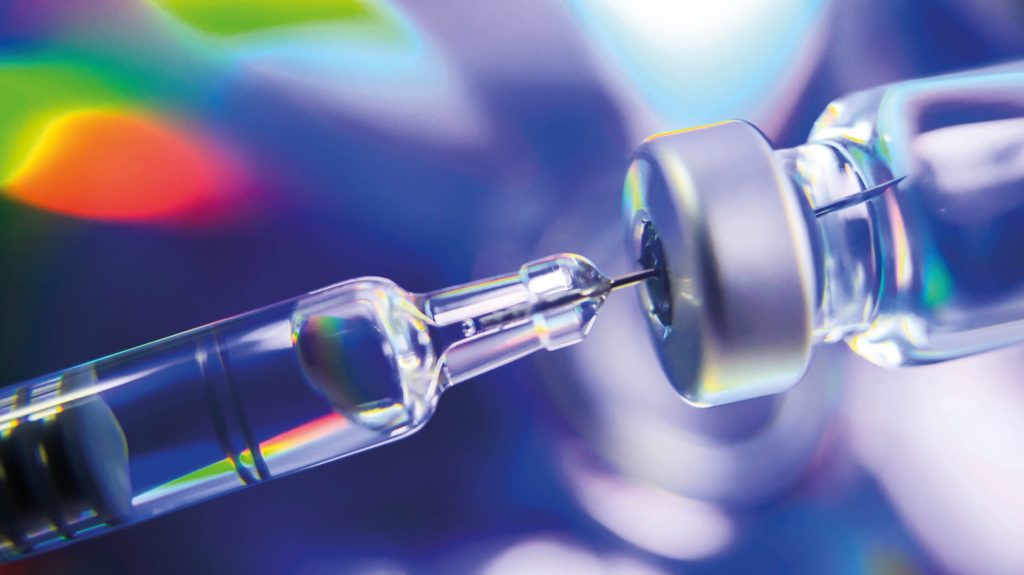 A syringe is being inserted into a vaccine.