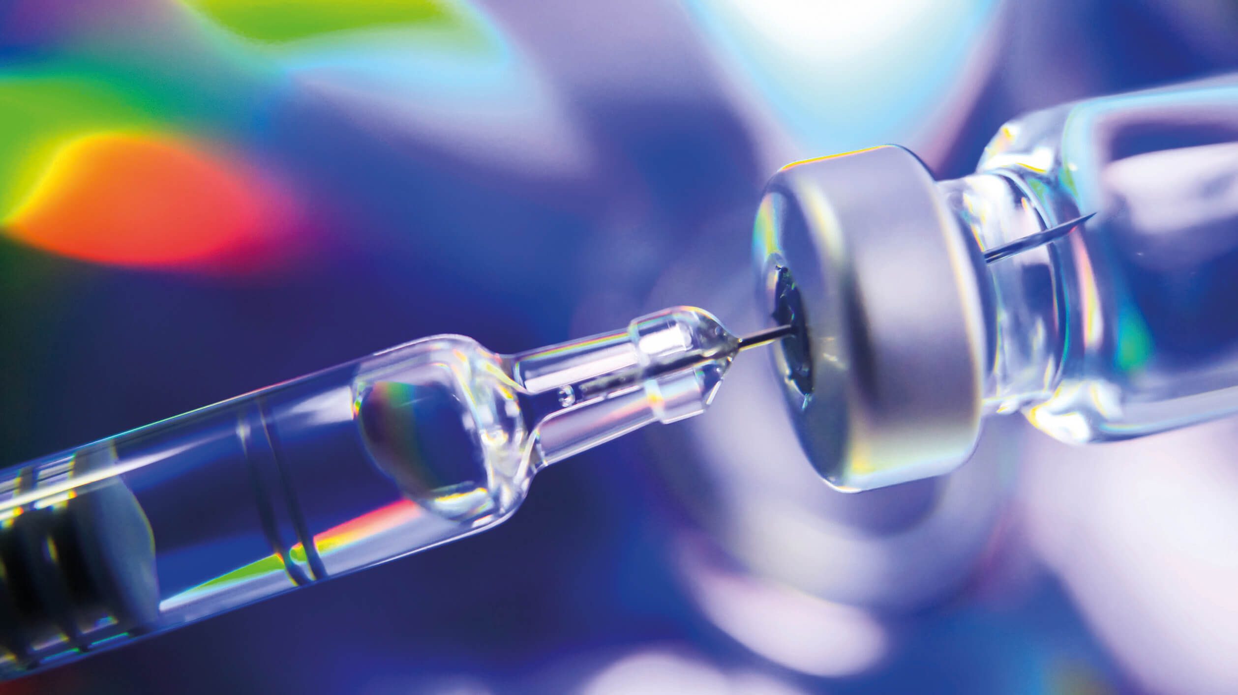 A syringe is being inserted into a vaccine.